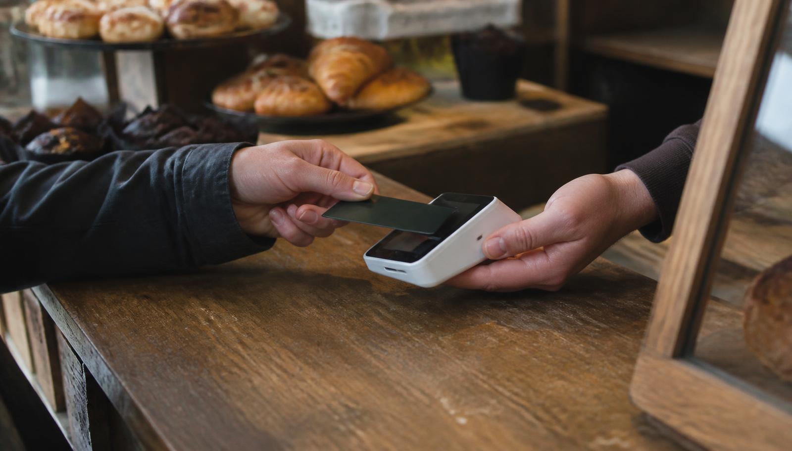 Small business owner accepting a credit card payment at the counter