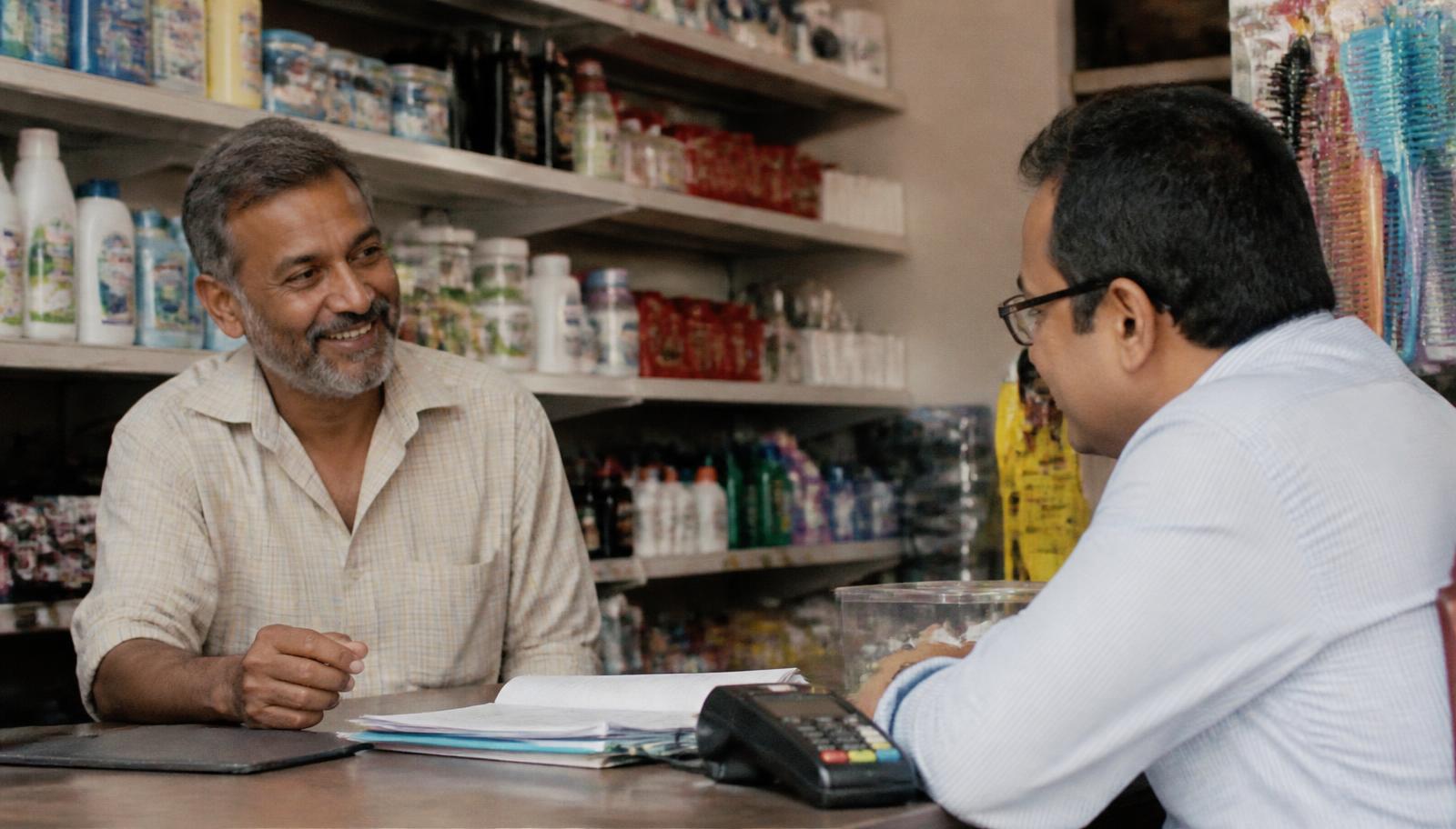 Business owner reviewing merchant services agreement and card payment equipment at a counter