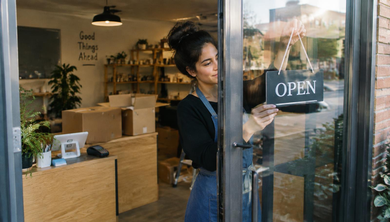 New small business owner setting up a card reader for the first time at a freshly opened storefront
