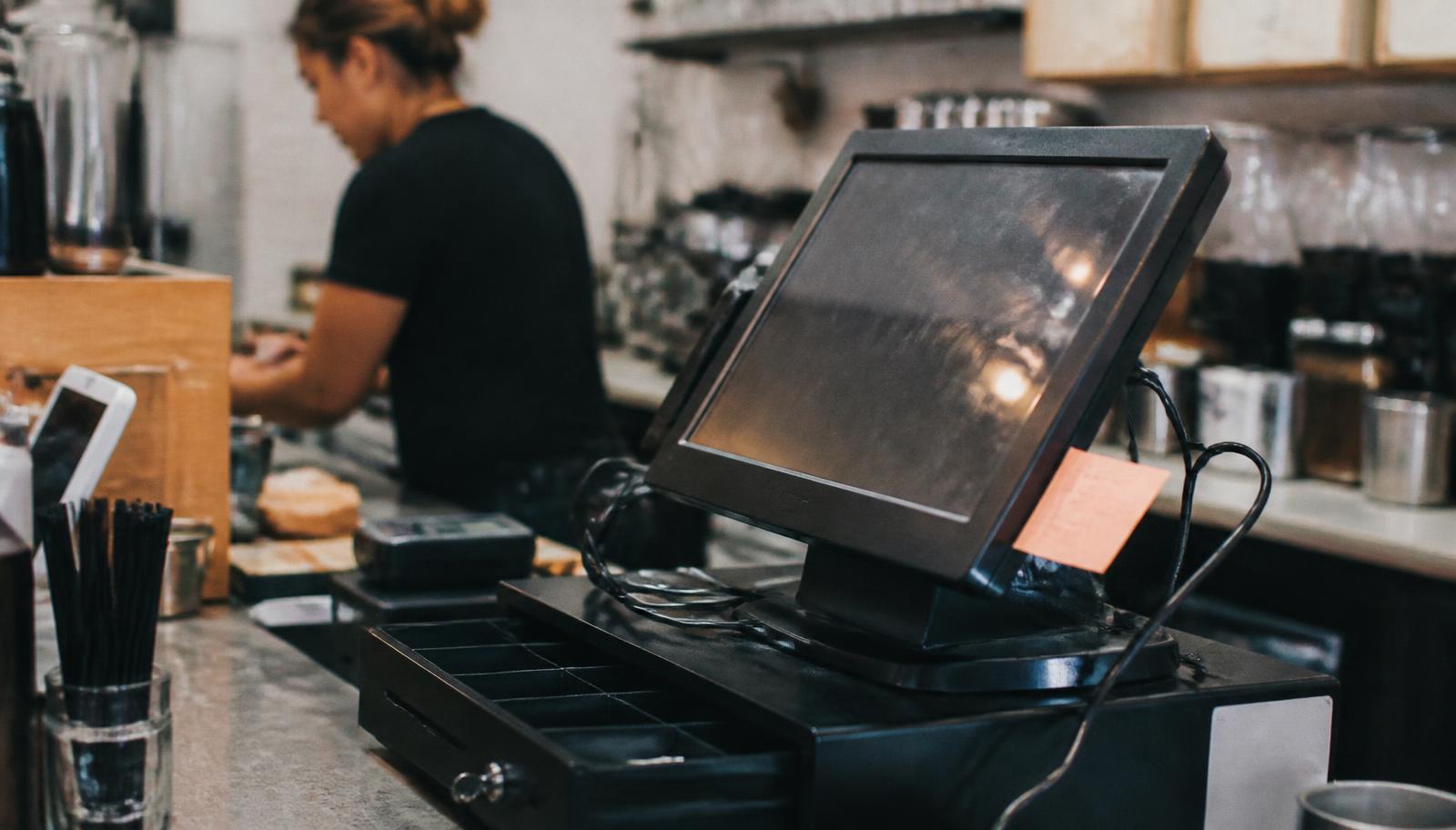 Small business owner ringing up a sale on a modern POS system