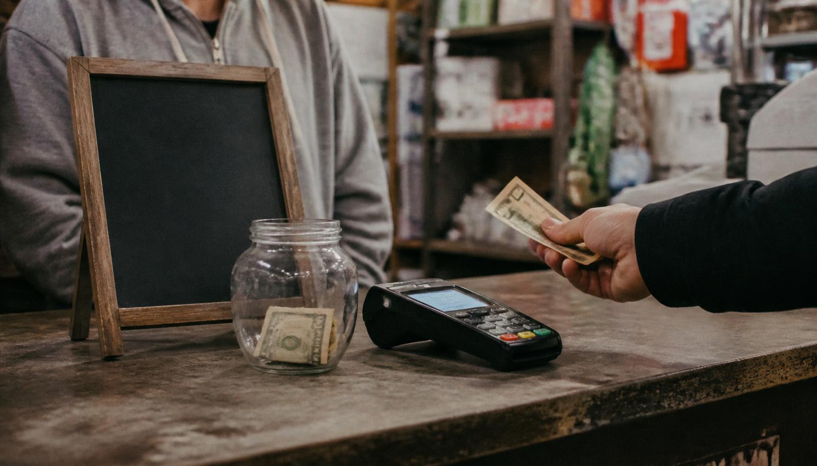 Small shop counter with a sign explaining zero fee credit card processing to customers